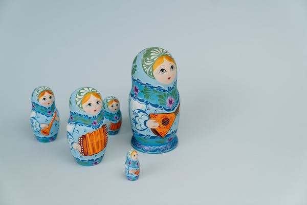 4 Blue Russian dolls of various sizes siting in a group. 